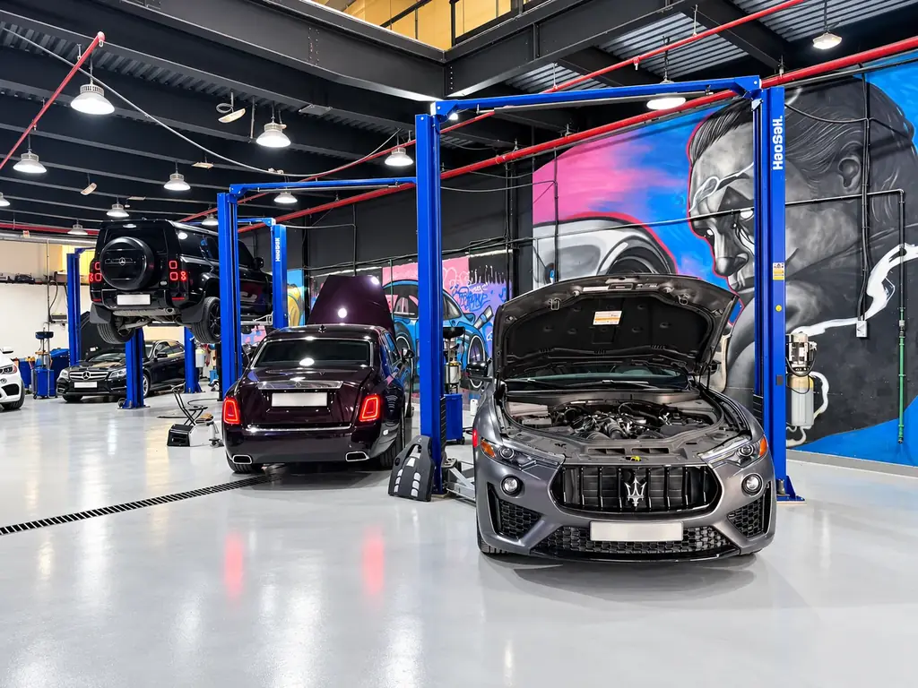 Maserati, Rolls-Royce and Mercedes-Benz cars inside Gomaa Garage workshop with vibrant mural in Al Quoz